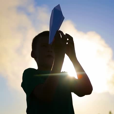 niño jugando con un avión de papel
