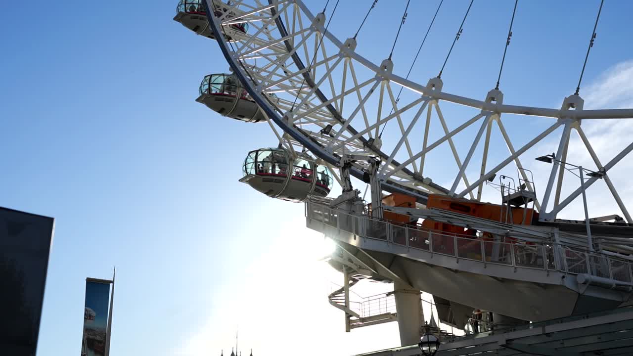 Sunbeams shining behind London Eye capsules on a very sunny day in London
