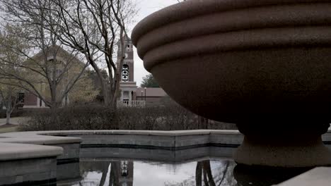 Fountain-with-still-water-on-the-campus-of-Ole-Miss-in-Oxford,-Mississippi-with-video-tilting-up
