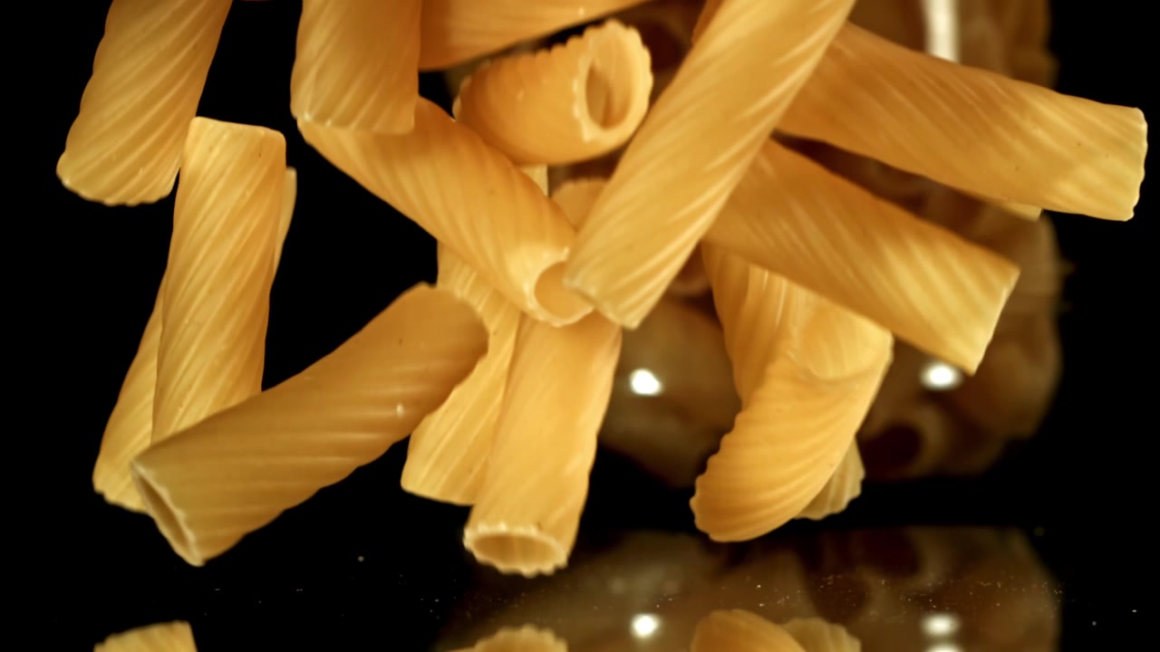 Rigatoni crudi che cadono al rallentatore