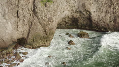 abandoned caribbean beach in the early morning. smooth fly in, towards a small cave inside a large cliffside. the waves crash into the rocks laying onshore.
4k uhd at 23.98 fps.
