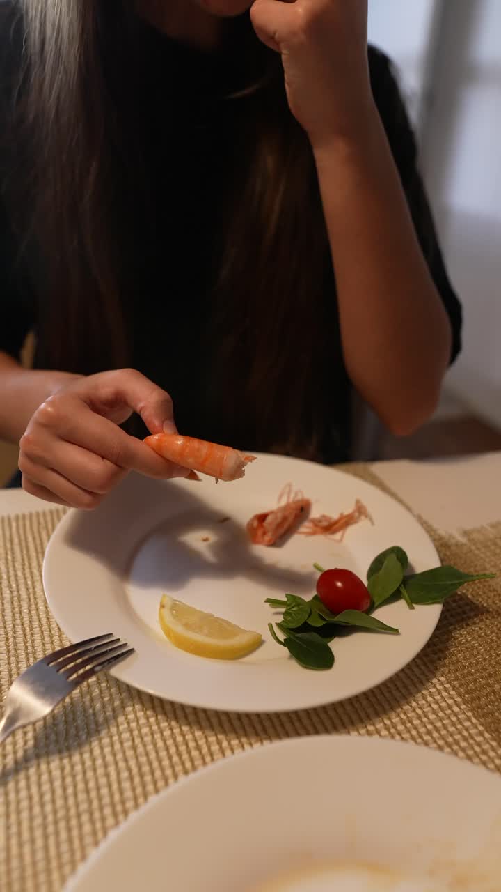 mujer comiendo una cena de camarones