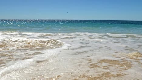 gentle waves crashing on rocks on tropical sandy beach, nosy be, nosy fanihy, madagaskar, africa