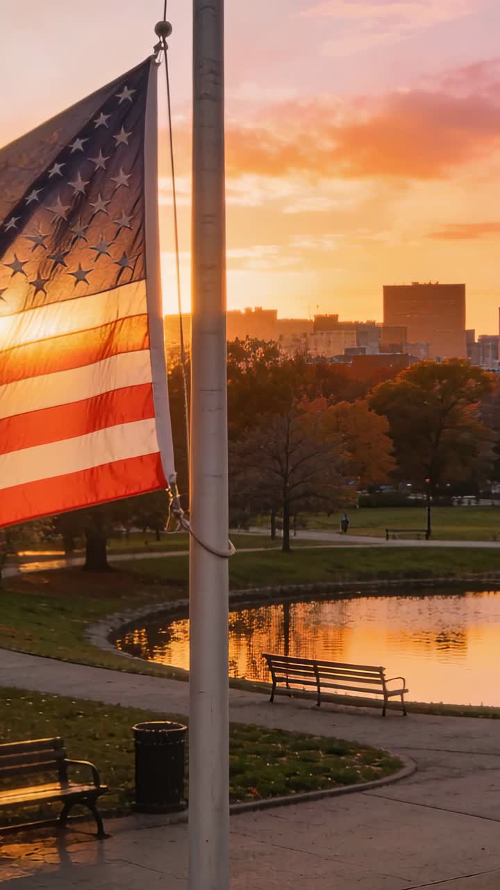 Bandiera americana al tramonto su un parco cittadino con laghetto e skyline