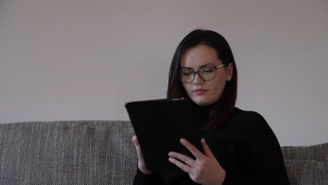 portrait of a serious young woman working on a tablet