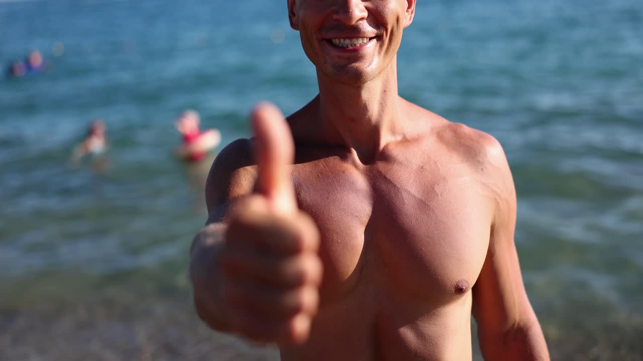 Man on the beach giving a thumbs up