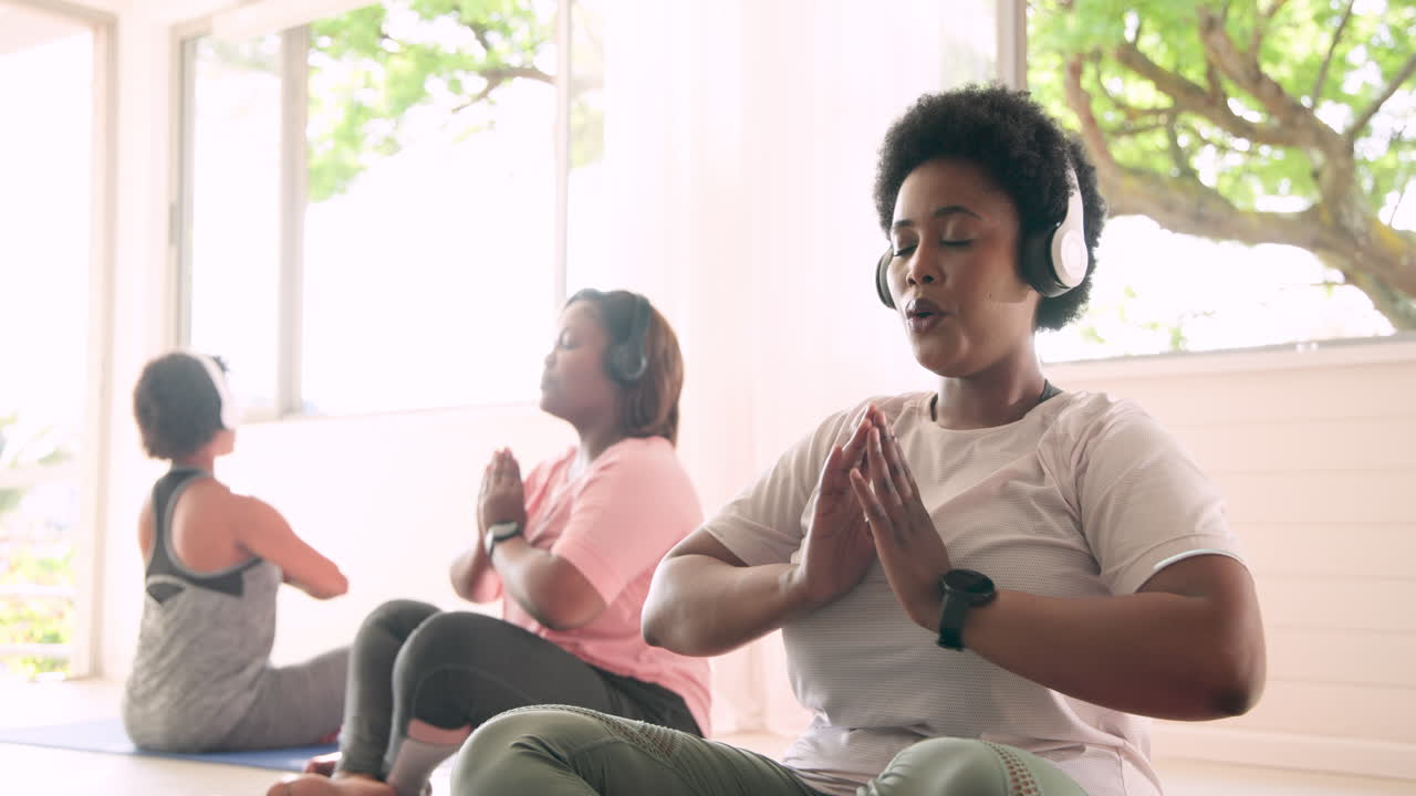 African American women meditating with headphones, finding peace and relaxation together