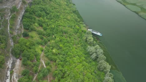 camera with the turn of the p axis, on the right side, the river is visible on which the boat a is moored, on the left side, one side of the mountain descent with green trees on the sides