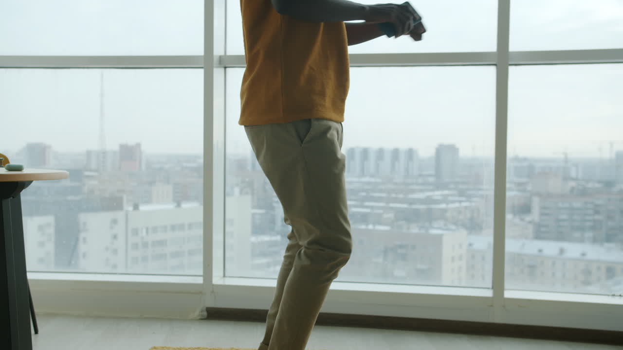 Man Dancing in Modern Apartment with City View