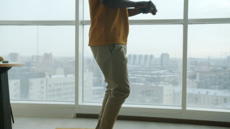 man dancing in modern apartment with city view