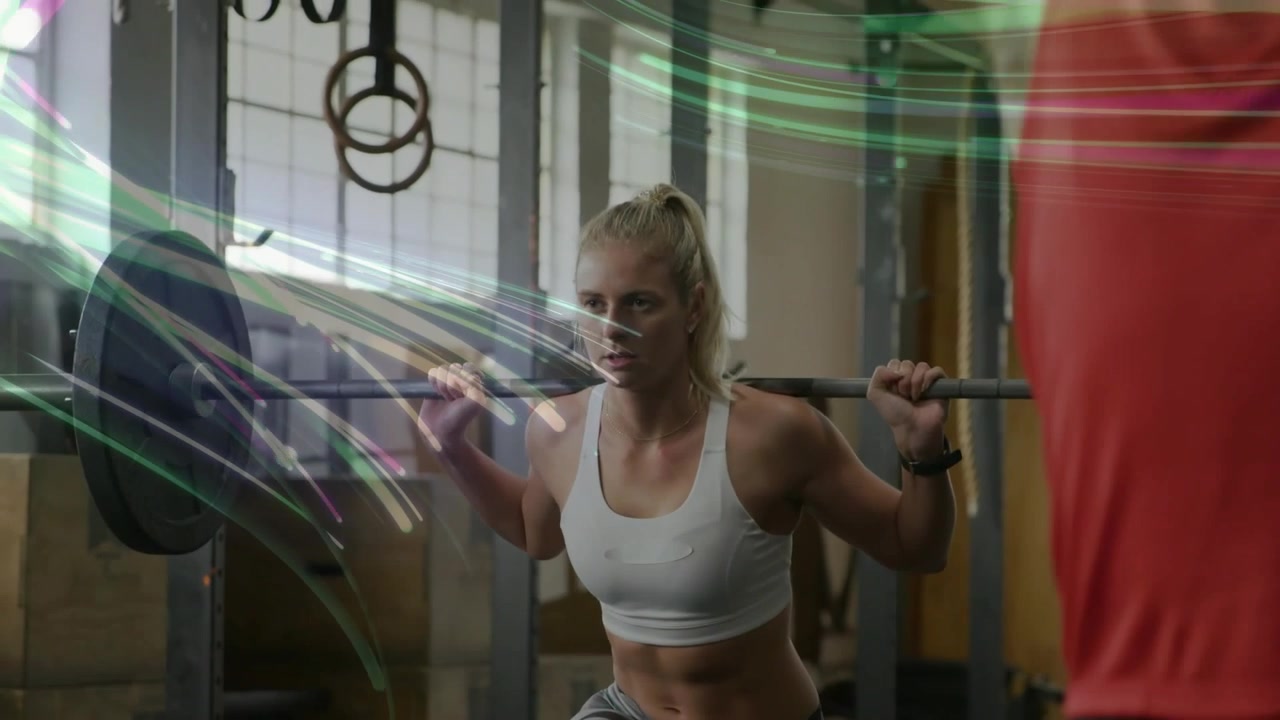 Woman stepping, lowering barbell in gym, lunging for power with color streaks sweeping over torso