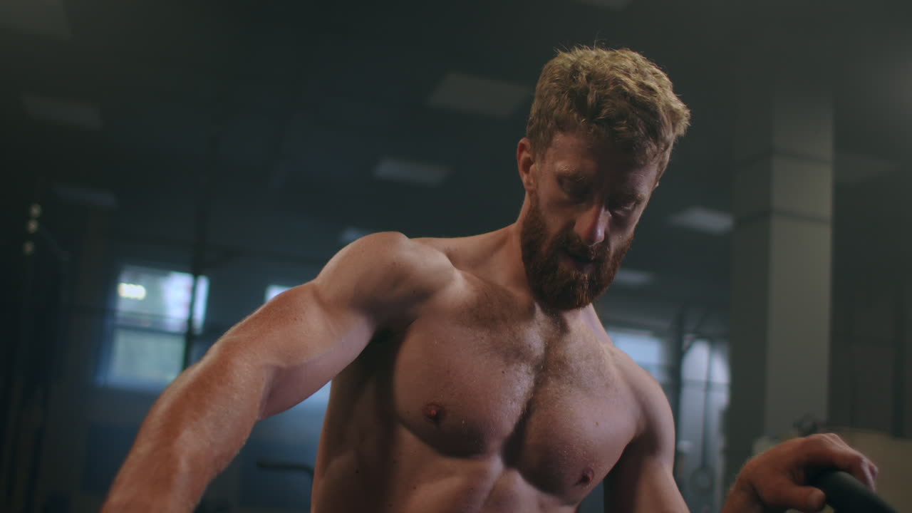 tiempo para descansar. joven hombre atlético en ropa deportiva buscando agotado mientras estaba de pie frente a las ventanas en el gimnasio.