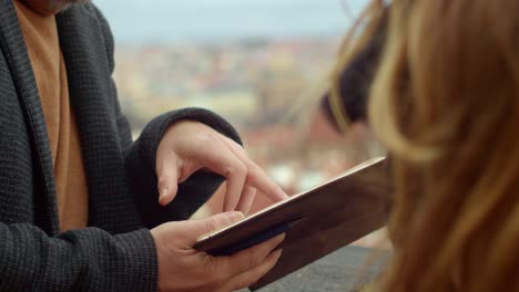 man holding diary or notebook in hands and reading poem to girl, outdoor windy closeup view