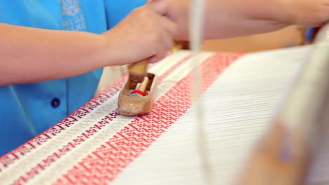 woman hand working with weaving loom at textile factory. textile industry