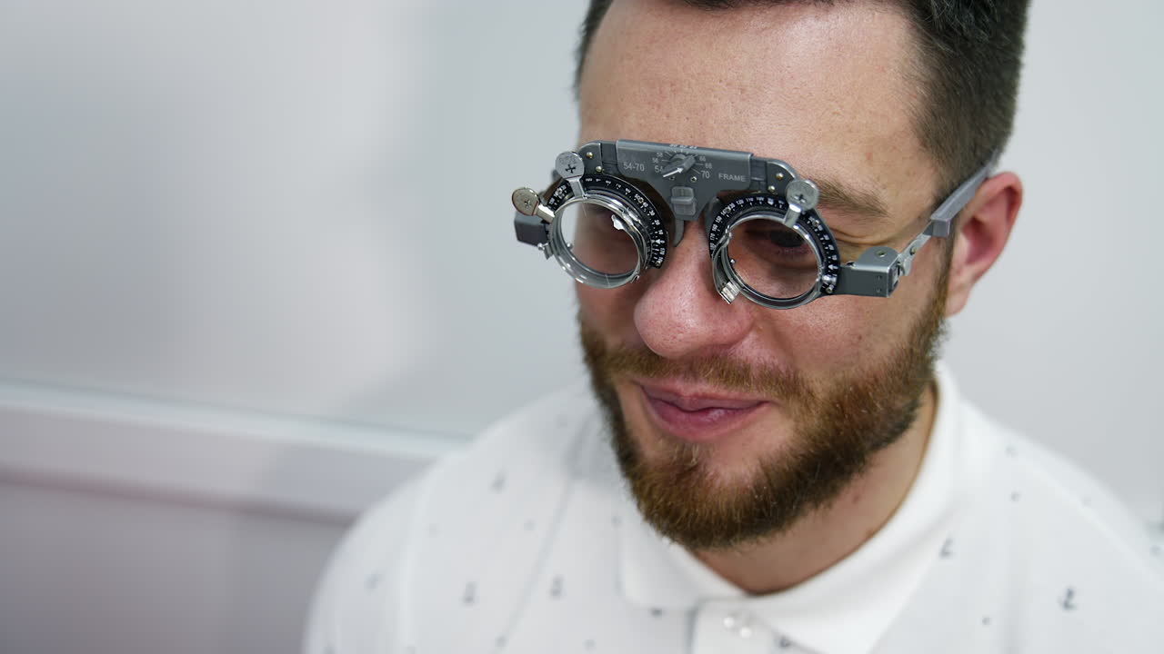 Handsome man at ophthalmology clinic. Special testing glasses with replacable lenses for vision correction on a male patient.