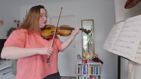 Mujer-Joven-Tocando-Instrumentos-De-Cuerda,-Leyendo-Notas-Musicales,-Cámara-Lenta