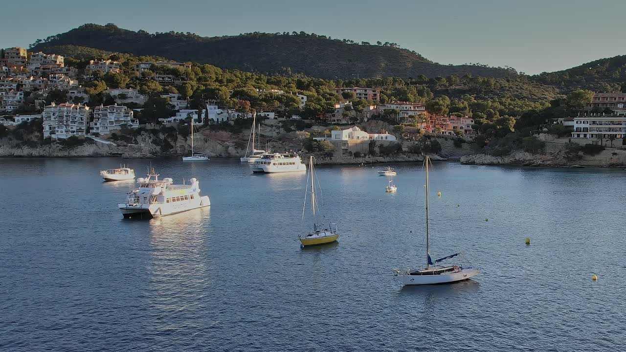 Boats floating in the calm waters of Mallorca, Spain during sunset