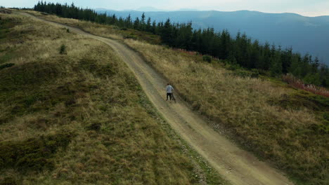 man with bike mountain view doing active sport hilly road woods background