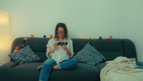 woman using smartphone on a couch at home