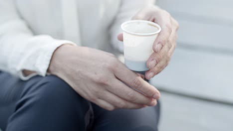 Close-Up-Of-An-Unrecognizable-Female-Office-Employee-Sitting-And-Drinking-Takeaway-Coffee-While-Talking-With-A-Colleague