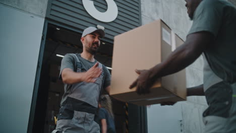 warehouse workers exchanging packages at a loading dock