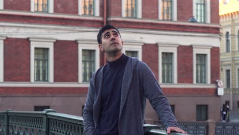 man looking up on a bridge in a city