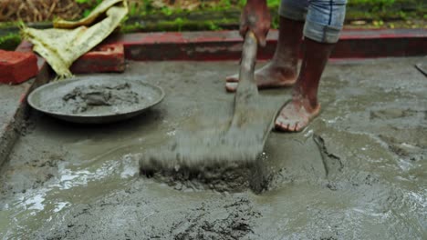 construction site in poor remote rural village in india labor working barefoot with cement