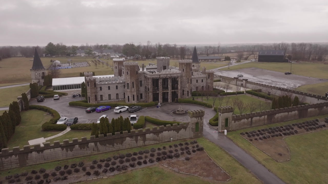 4k drone shot tracking through a cloud to reveal a stone castle in the green Ireland