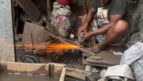 man is using a metal grinder to shape a piece of metal into a blade