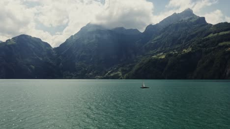 swiss lake with sailboat and mountains