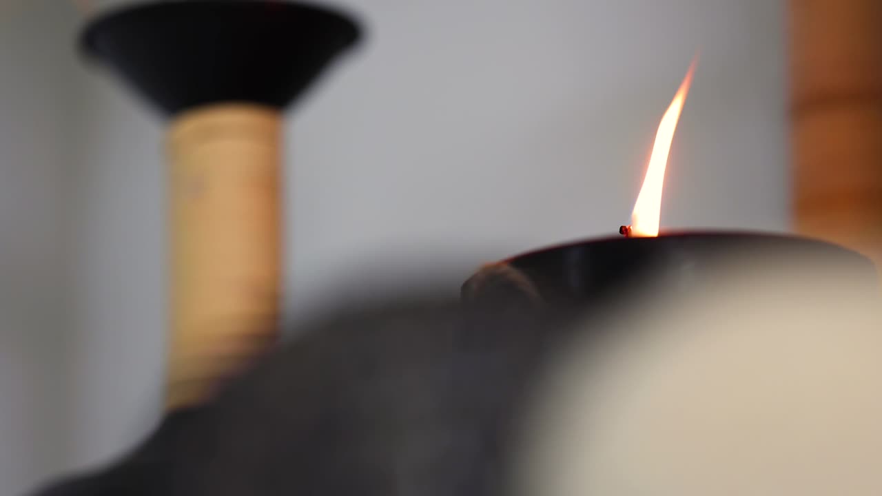 comenzando con la llama de la vela fuera de foco, cambiando gradualmente el enfoque a través de bolas decorativas en primer plano que proyectan calma y tranquilidad.