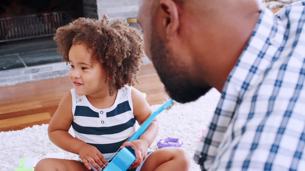 Young black girl playing ukulele and singing with her dad