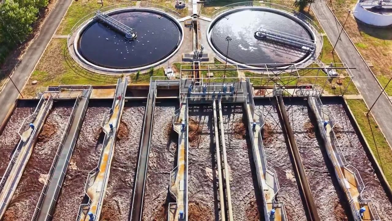 View of a water treatment facility showing multiple treatment tanks and processing areas during daylight hours