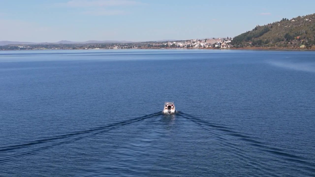 Piccolo motoscafo che attraversa le acque calme del Lago Nahuel Huapi, Bariloche, Patagonia, Argentina