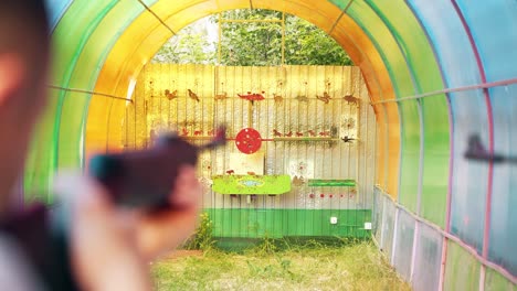 close-up young guys shoot at a shooting range from pneumatic guns reload guns