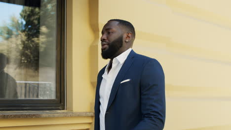 handsome afro businessman late. focused man walking fast at urban street.