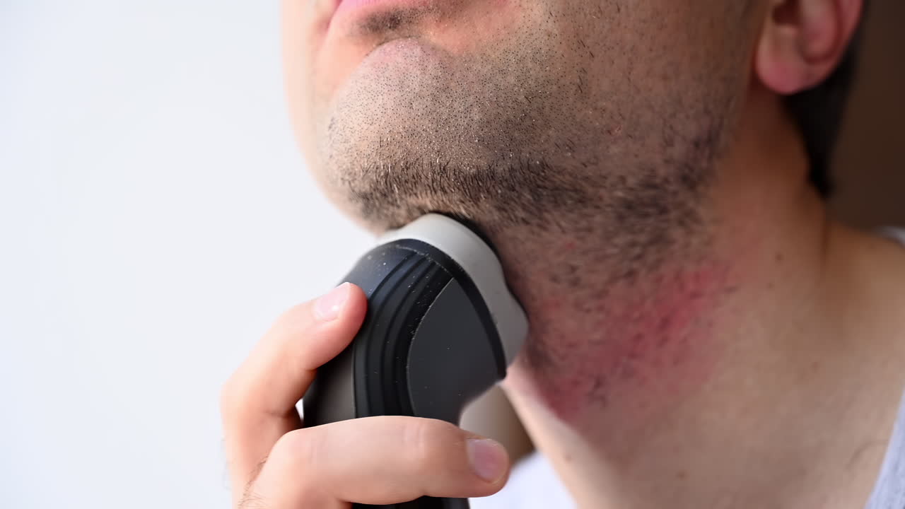 Close up of man using electric shaver on chin and face