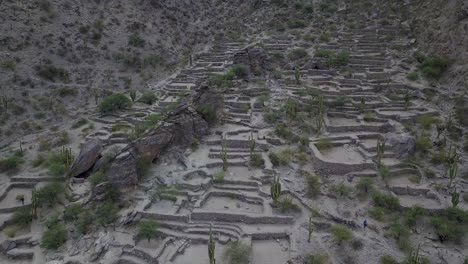 Aerial-shot-tilts-to-reveal-the-Quilmes-Ruins-in-Argentina,-South-America