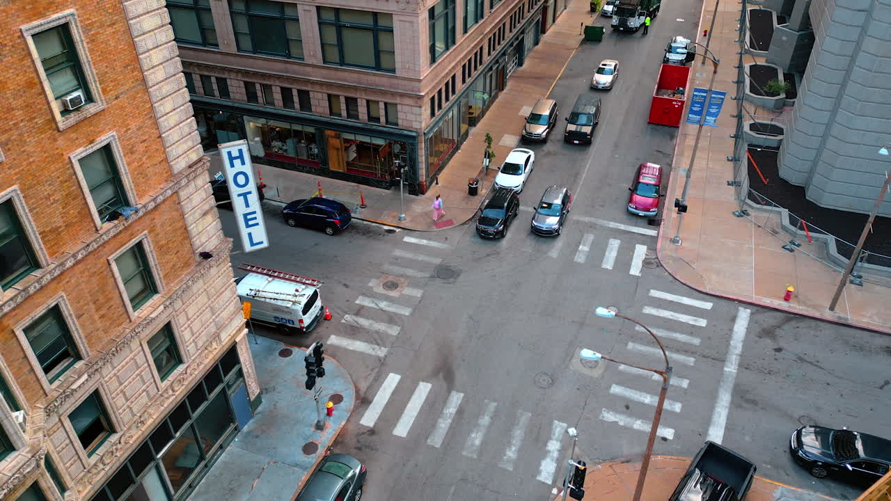 Saint Louis USA, 14 August 2025: Woman crosses the crossroads in the street of St. Louis, Missouri, USA. Cars wait for the light and start to go. Aerial view