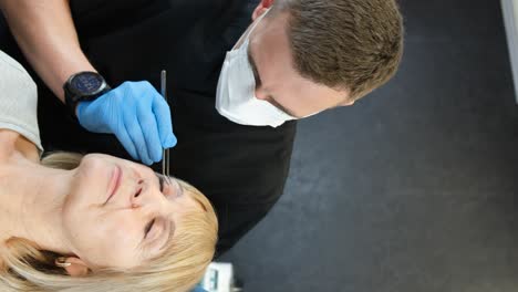 specialist performing an eye examination or beauty treatment