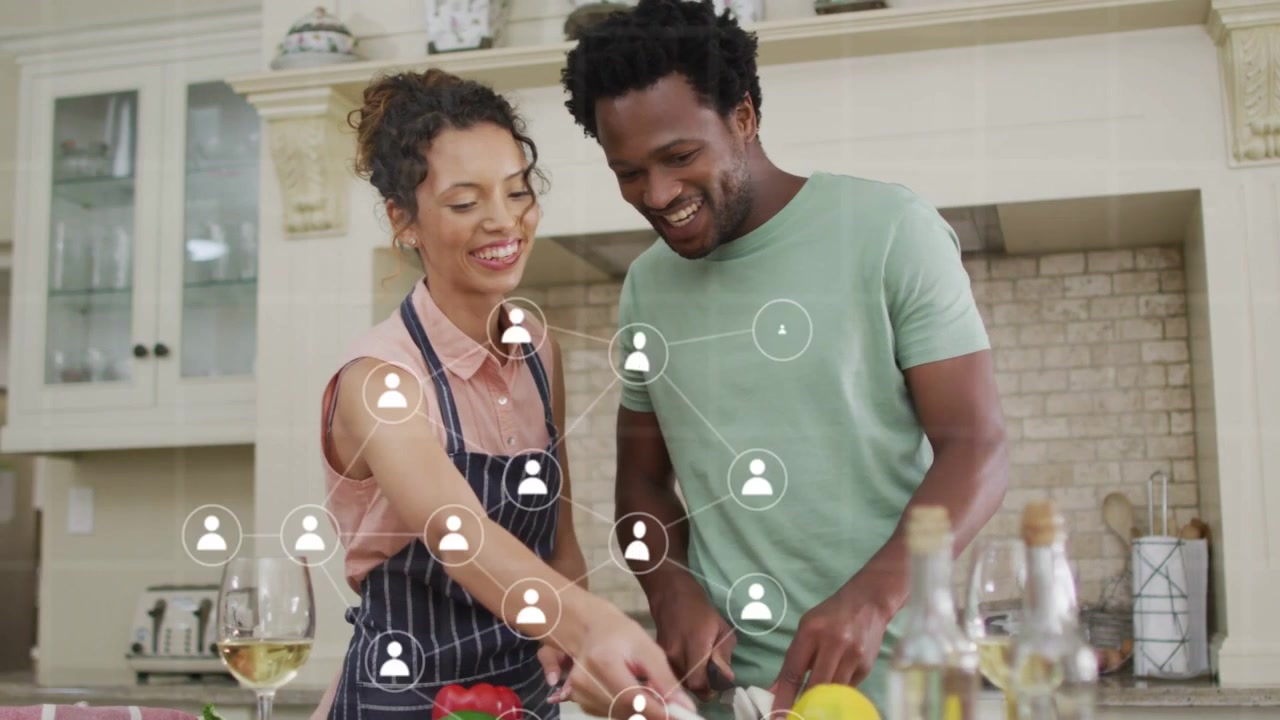Phone ping starting recipe icons while couple making food; overlays fading as couple smiling
