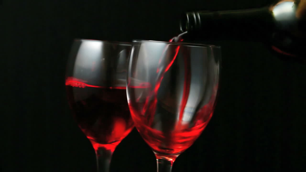 Dos copas de vino tinto siendo servidas
