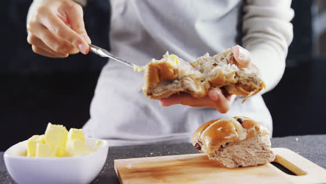 woman applying butter over multigrain bun 4k