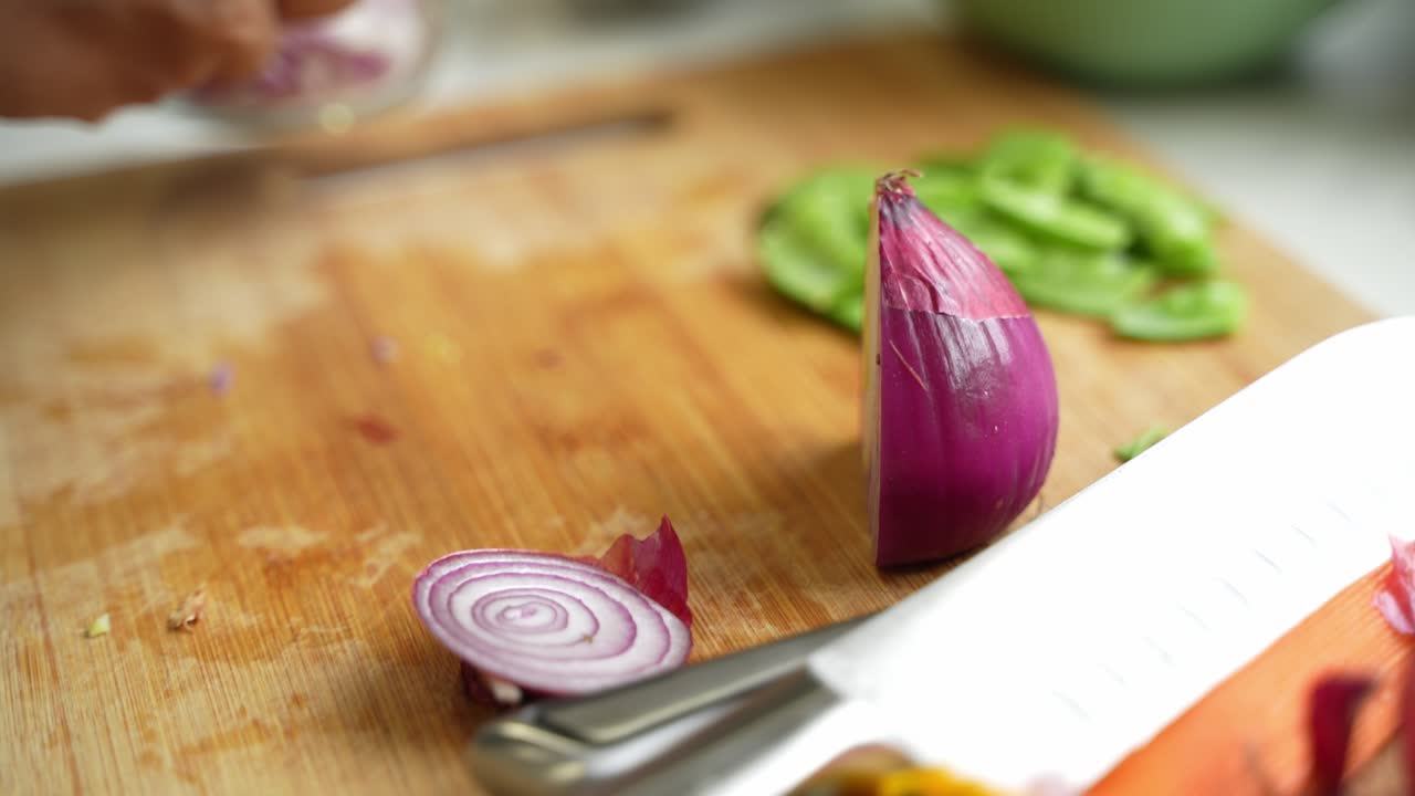 Chopping of onions on chopping board using sharp knife.