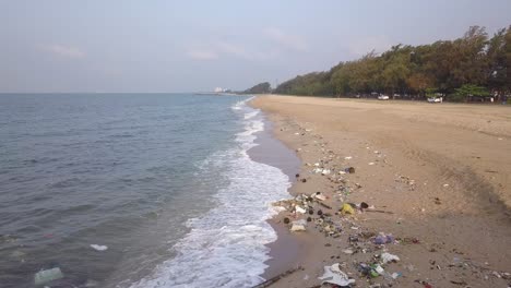 tranquil beach in rayong, thailand polluted with garbage