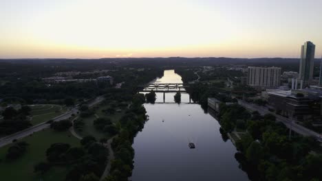 vista aérea sobre un ferry en el río colorado en austin, crepúsculo en texas, estados unidos