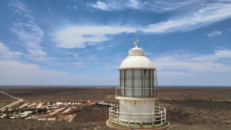 Faro-Histórico-Alto-Y-Antiguo-En-Una-Colina-Al-Lado-Del-Azul-En-El-Océano-Pacífico-En-Un-Día-Parcialmente-Nublado-Cerca-De-Exmouth,-Australia-Occidental