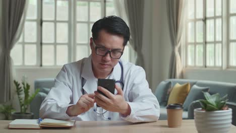 man doctor use mobile phone at home office, video in 4k