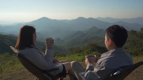 couple enjoying coffee with a scenic mountain view