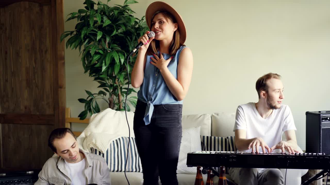 기쁜 음악가, 키보디스트와 기타리스트가 연주하고, 그들의 여자 친구 보컬이 노래하고 춤을 추고 있습니다.